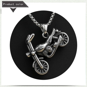 Close-up of vintage stainless steel motorcycle pendant with detailed retro engine textures