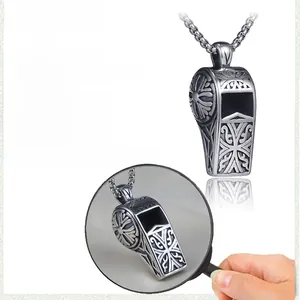 Macro detail of retro stainless steel whistle pendant with intricate engraved patterns