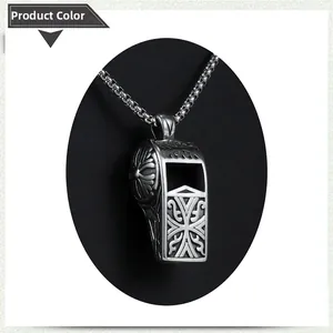 Detailed view of a vintage silver whistle pendant with intricate vine and cross engravings