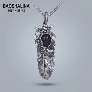 Détail du pendentif plume rétro avec incrustation de gemme noire sur chaîne acier