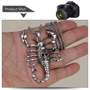 Détail du pendentif scorpion vintage en acier avec motif crâne sur chaîne métallique