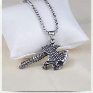 Detail of gothic stainless steel axe pendant with skull engraving on box chain necklace