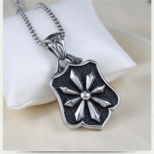 Macro shot of retro shield pendant with star relief on stainless steel chain