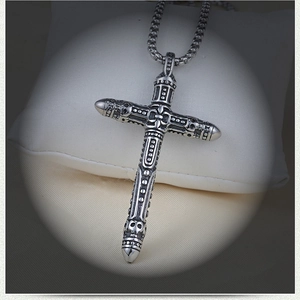 Détail d'un collier croix gothique en acier inoxydable avec relief de crâne poli