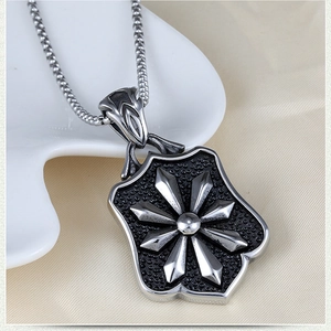 Close-up of vintage steel shield pendant with octagonal star relief on round link chain
