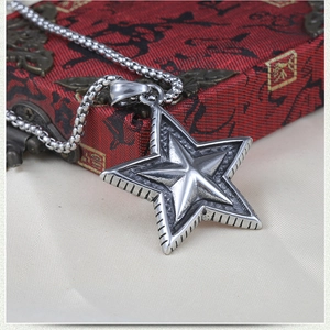Macro detail of retro stainless steel star pendant with textured industrial finish