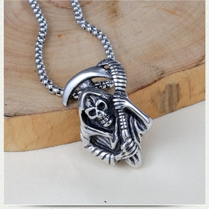 Close-up of vintage stainless steel grim reaper skull pendant with a bead chain