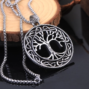 Stainless steel Tree of Life pendant necklace with Celtic knot patterns on wood background