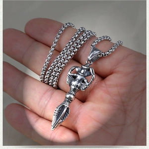 Pendentif Vajra Phurba en acier inoxydable rétro tenu en main sur une chaîne