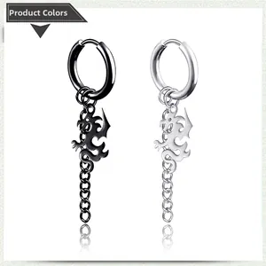 Detalle de pendientes de dragón en acero negro y plateado con borlas de cadena metálica