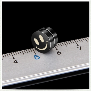 Macro shot of 8mm black magnetic smile earring against a steel ruler showing scale