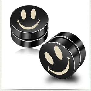 Macro shot of black magnetic stud earrings with white smiley face design on white background