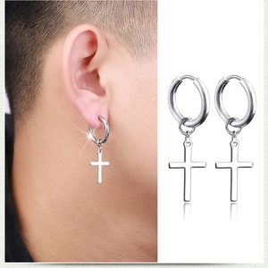Gros plan sur des boucles d'oreilles homme anneau et croix en acier inoxydable