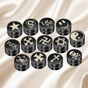 Set of 14 black magnetic stud earrings with various laser-engraved symbols on silk fabric