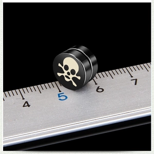Black magnetic skull stud earring shown with a ruler to measure 10mm diameter size