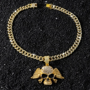 Vue détaillée d'une chaîne cubaine en or avec pendentif tête de mort ailée sertie