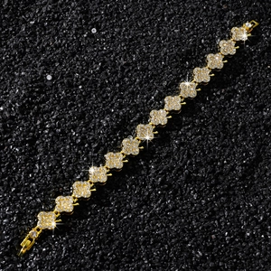 Détail d'un bracelet trèfle doré avec pavé de diamants et 15 motifs floraux étincelants