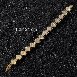 Bracelet chaîne floral doré avec cristaux scintillants sur fond de pierres noires