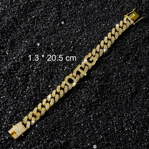 Détail macro du bracelet à maillons cubains dorés de 13mm avec design de lettres OTG