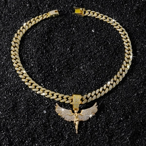 Détail macro du pendentif aile d'ange doré serti de zircons sur une chaîne cubaine