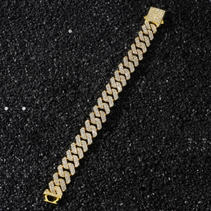 Macro detail of 14mm iced out diamond rhombus link chain with gold base on dark stones