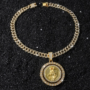 Détail d'une chaîne cubaine dorée avec pendentif Santa Muerte serti de strass