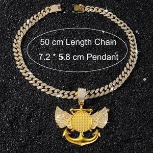 Détail de la chaîne cubaine dorée et pendentif ailes avec ancre en zircons cubiques