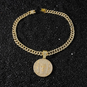 Macro view of iced out gold cuban chain necklace with a large diamond cross disc pendant