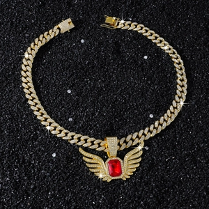 Close-up of gold iced-out Cuban chain and wing pendant with large red gemstone