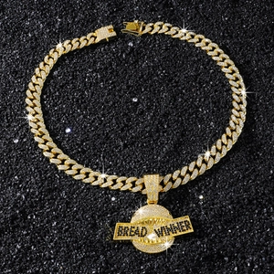 Détail du pendentif requin doré serti de zircons avec gravure Bread Winner sur chaîne