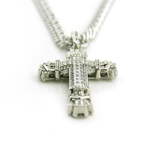 Macro detail of men's hip-hop cross pendant with iced-out crystals and curb chain