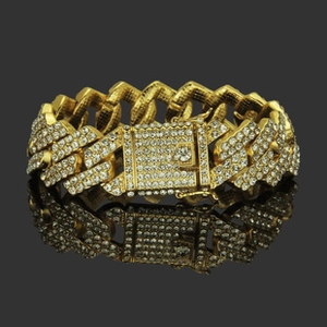 Detail of gold Cuban link bracelet with iced-out cubic zirconia and square lock clasp