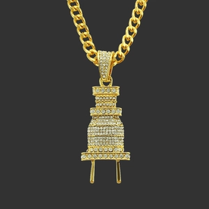 Makroaufnahme des Hip-Hop-Anhängers in Steckerform mit Goldbeschichtung und weißen Strass