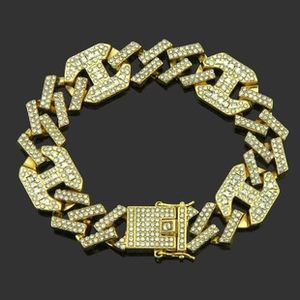 Close-up of iced out H-link hip hop bracelet with gold finish and sparkling rhinestones