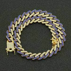 Macro detail of iced-out Cuban link bracelet with blue and white cubic zirconia stones