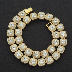 Macro detail of gold-plated cuban link chain featuring iced out square zircon stones and clasp