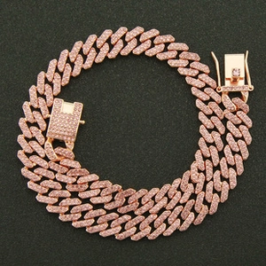 Close-up of rose gold Cuban link bracelet with pink rhinestones on black texture