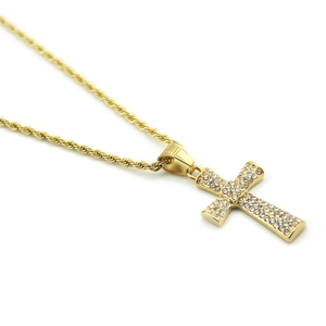 Gros plan détaillé d'un pendentif croix hip-hop doré avec cristaux sertis et chaîne torsadée