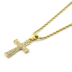 Détail du pendentif croix dorée avec pierres de zircone et collier à chaîne torsadée