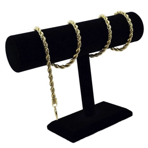 Ensemble collier et bracelet en chaîne corde dorée sur un support de bijoux noir