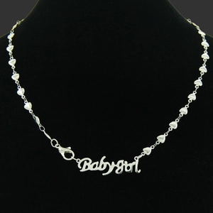 Detail view of silver Babygirl letter necklace on heart-shaped chain links with lobster clasp
