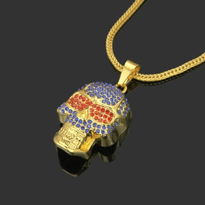 Macro shot of gold hip hop skull pendant with red eyes and blue rhinestones