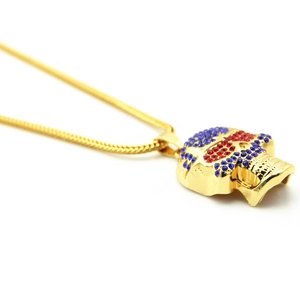 Detailed view of hip hop skull pendant with blue and red rhinestones on gold chain