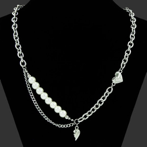 Detail of a punk style Y2K necklace with silver chains, pearls and heart pendants