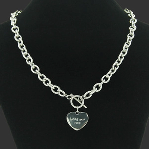Detail of silver heart pendant engraved with Love you more on a toggle clasp necklace