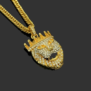 Macro shot of hip hop gold plated lion head pendant with iced out crystals and Cuban chain