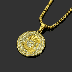 Macro shot of gold-plated box chain and round Jesus medallion encrusted with rhinestones