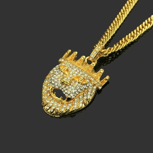 Close-up of golden hip-hop lion head pendant with sparkling rhinestones and crown detail