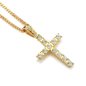 Vue macro d'un pendentif croix hip-hop avec cristaux brillants et finition dorée