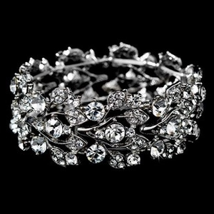 Macro view of wide silver floral bracelet featuring intricate leaf patterns and rhinestones